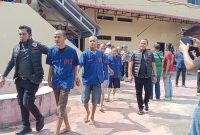 Kanit Reskrim Polres Asahan bersama tim menggiring 13 orang pelaku kelokasi konferensi pers. (foto : miko franata)